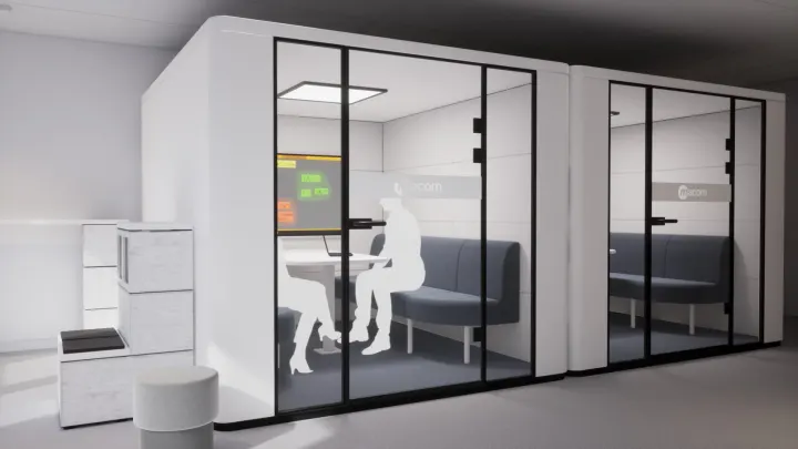 Two glass meeting pods with benches and a display inside